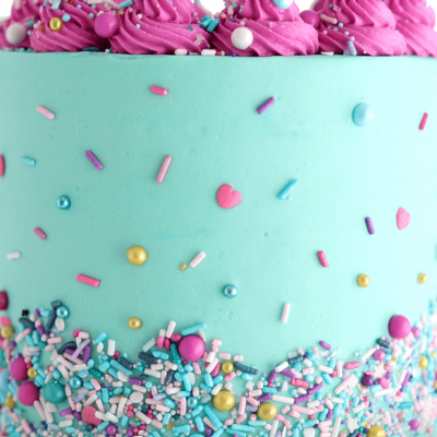 Bolo azul turquesa com chantilly rosa e confetis coloridos