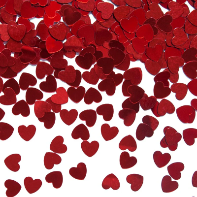 Confetes brilhantes vermelhos em forma de coração sobre fundo branco