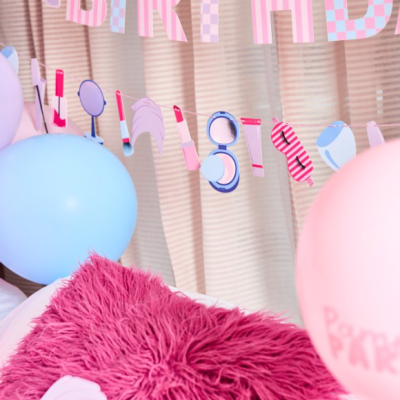 Varal decorativo de maquilhagem pendurado numa cortina com balões e almofada