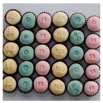 Doces pequenos coloridos com textos e números sobre superfície clara