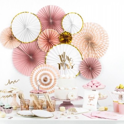 Conjunto decorativo para festa com abanicos de papel rosa e branco, bolo gatronómico e doces sobre mesa branca