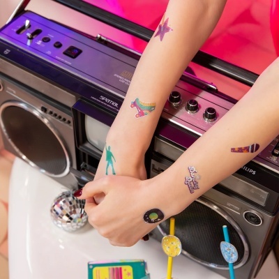 Braços com tatuagens temporárias sobre rádio cassete retro Philips