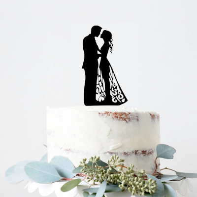 Bolo branco com topper em silhueta de casal abraçado e folhagem verde na base