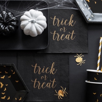 Artigos de festa Halloween com abóboras, guardanapos, copos, canudos e bandejas em preto, branco e dourado.