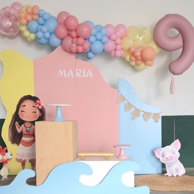 Decoração festa com painéis coloridos, balões pastel, figuras de Moana, porquinho e balão número 9