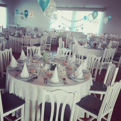 Mesa de jantar redonda decorada com toalha branca e balões azuis e brancos