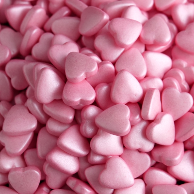 Pequenos corações rosa brilhantes e lisos aglomerados