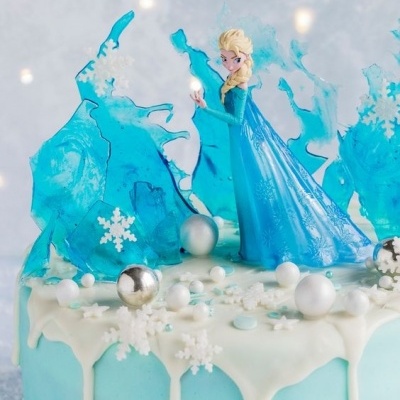 Bolo decorado com personagem Elsa e motivos de gelo e neve