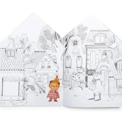 Livro infantil aberto com ilustração a preto e branco e boneca colorida.