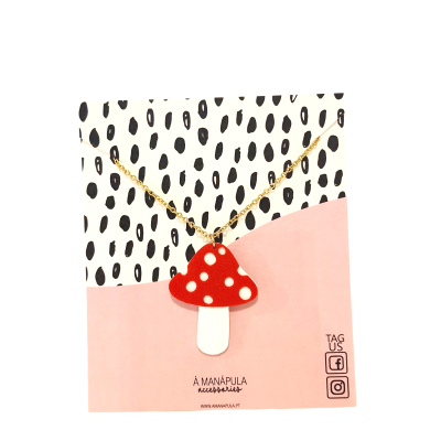 Colar com pendente de cogumelo vermelho e branco em cartão de embalagem colorido