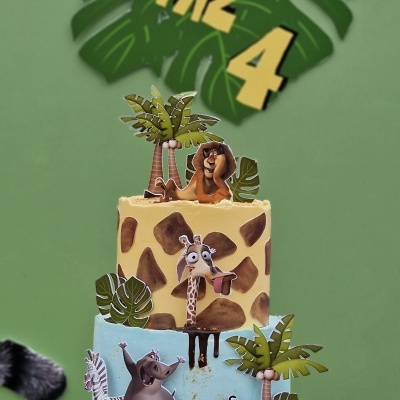 Bolo de aniversário Madagascar com decoração colorida e texto de fundo