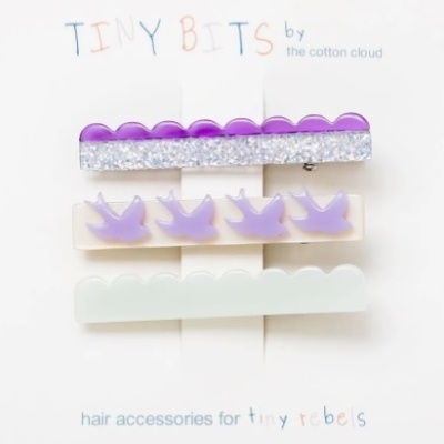 Conjunto de ganchos de cabelo lilás e branco com padrões e texto em cartão branco