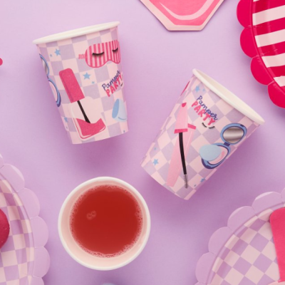 Copos de papel decorados com tema de cuidados pessoais sobre fundo lilás