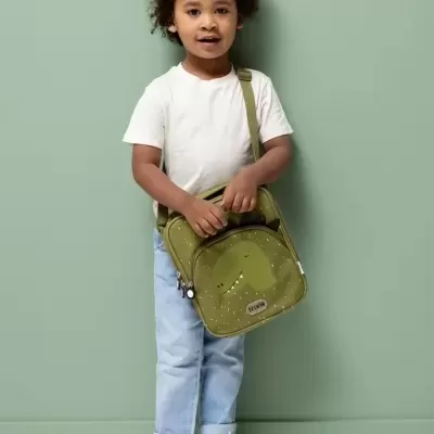 Criança com mochila infantil verde com desenho de dinossauro