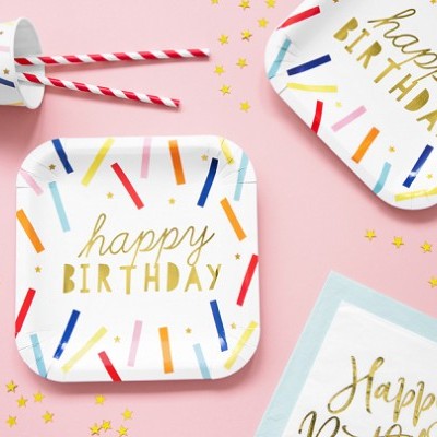 Placas de papel com texto 'happy BIRTHDAY' decoradas com riscas coloridas e confetes dourados