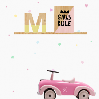 Estante com letra M e bloco GIRLS RULE, carro de brinquedo rosa e estrelas coloridas no fundo