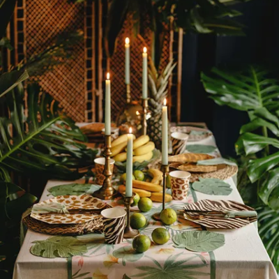 Mesa de jantar decorada com tema tropical e velas acesas