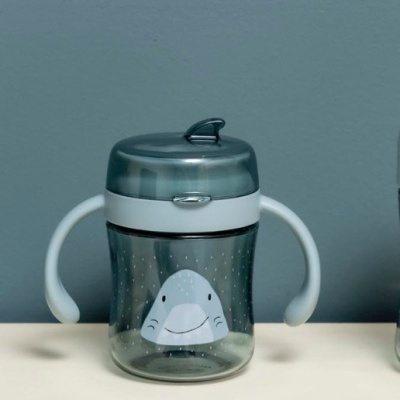 Copo infantil transparente com tampa e pegas brancas e desenho de tubarão