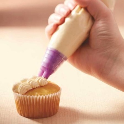 Decoração de cupcake com saco de confeitar creme e ponta roxa