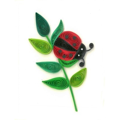 Joaninha de papel feita com quilling em folhas verdes
