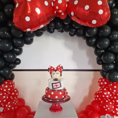 Bolo temático de Minnie com decoração de balões em arco