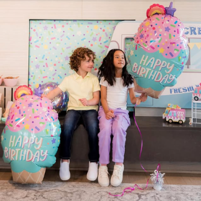 Crianças com balões de gelado rosa e azul com texto HAPPY BIRTHDAY