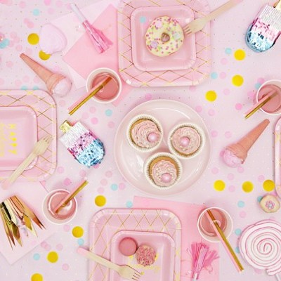 Mesa festiva com artigos variados cor-de-rosa, doces e decoração colorida