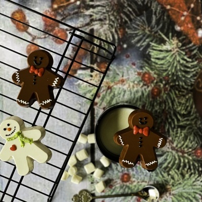 Biscoitos de gengibre decorados em grelha metálica e fundo com ramos de pinheiro e bolas vermelhas