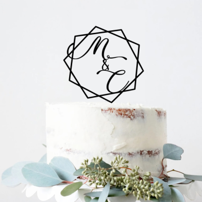 Bolo branco com decoração de folhas verdes e logotipo preto 