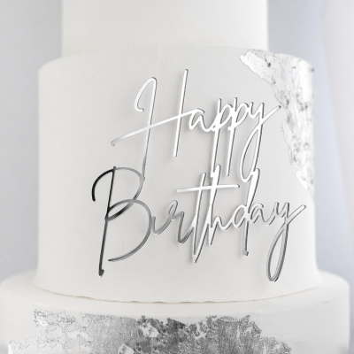 Bolo branco de dois andares com decoração prateada e placa Happy Birthday