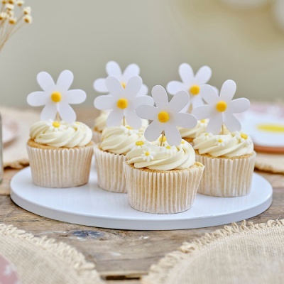 Seis cupcakes com cobertura branca e toppers de flores brancas e amarelas