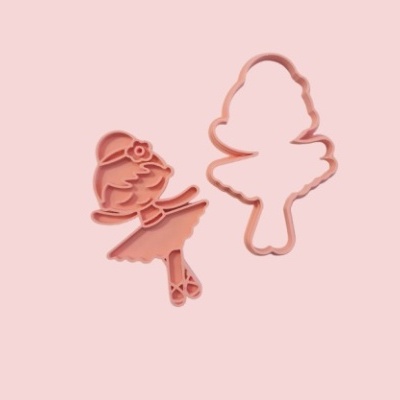 Dois cortadores de biscoito rosa em forma de bailarina sobre fundo rosa claro