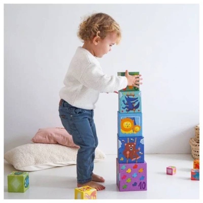Criança a empilhar blocos de madeira coloridos com números e desenhos de animais