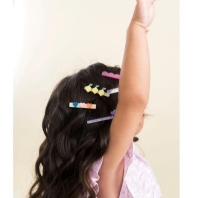 Cabelo longo castanho com molas de cabelo coloridas e vestido lilás
