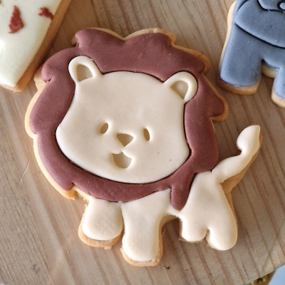 Bolacha decorada em forma de leão com glacê castanho e bege