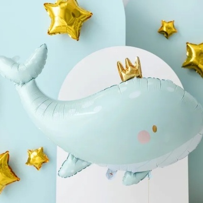 Balão em forma de baleia azul com coroa e balões estrela dourados em fundo azul