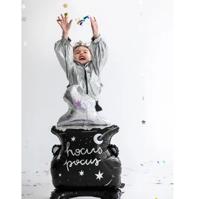Balão preto em forma de caldeirão com texto, criança vestida em prateado em fundo branco