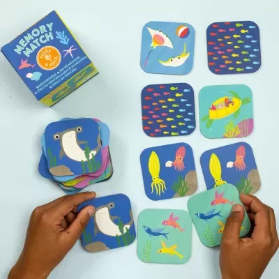 Cartas do jogo Memory Match com desenhos de peixes e caixa azul do jogo.