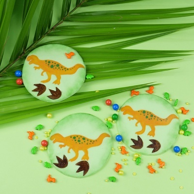 Macarons verdes com desenho de dinossauro e granulados coloridos
