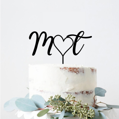 Bolo branco com cobertura cremosa e decoração verde e azul com topo preto em forma de letras e coração