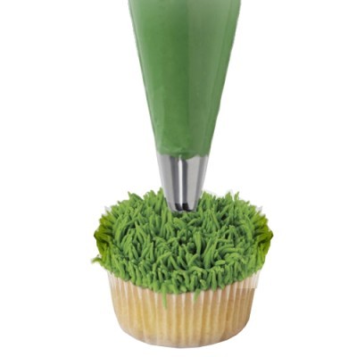 Cupcake a ser decorado com saco de pasteleiro verde e bico metálico