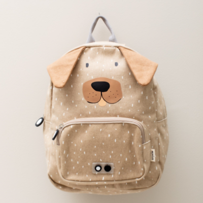 Mochila infantil bege com desenho de rosto de cão e orelhas castanhas em tecido