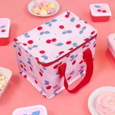 Mala térmica rosa com padrão de cerejas e caixas vermelhas com tampas rosas decoradas com cerejas