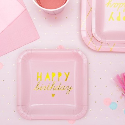 Prato rosa de papel com texto HAPPY birthday em amarelo numa festa com decoração rosa