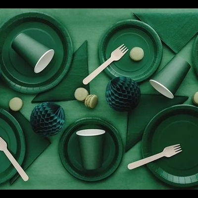 descaráveis verdes com talheres de madeira, ornamentos e macarons numa mesa verde