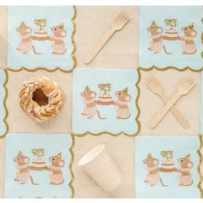 Decoração para festa infantil com guardanapos azuis, copos brancos, garfos de madeira e doces tipo rosquinhas