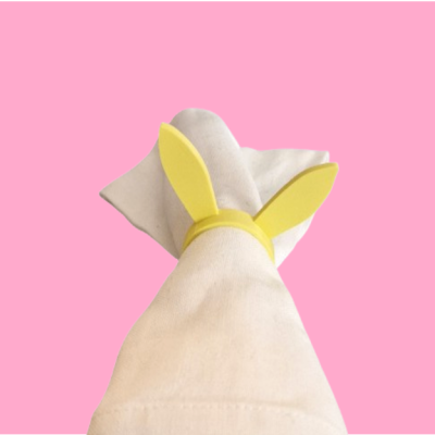 Porta-guardanapo amarelo em forma de orelhas de coelho com guardanapo branco