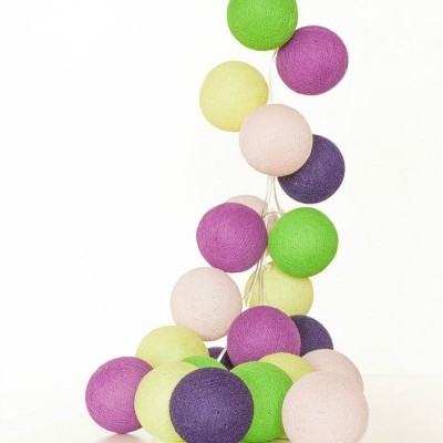 Luzes decorativas de bolas coloridas em tecido sobre superfície branca