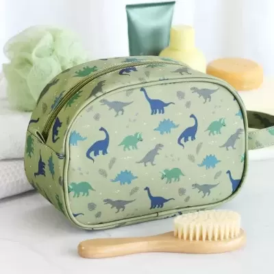 Estojo verde claro com padrão de dinossauros e escova de cabelo em bancada branca
