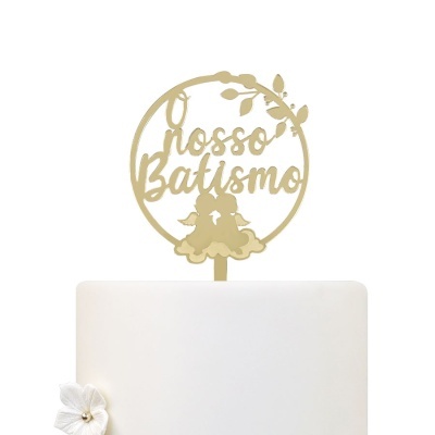 Topo de bolo dourado com texto 'O nosso Batismo' e dois anjos sobre bolo branco